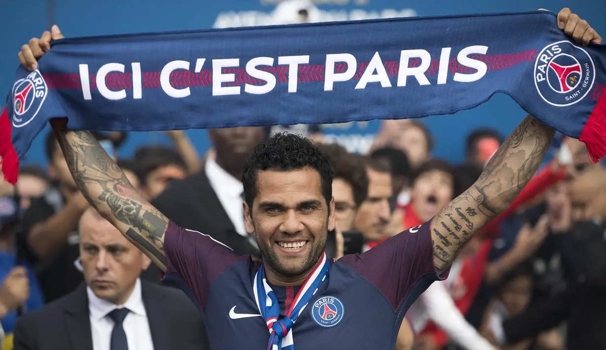 Mantan bek Juventus, Dani Alves, mengangkat syal saat diperkenalkan sebagai pemain baru PSG di Stadion Parc des Princes, Paris, Rabu (12/7/2017). (EPA/Ian Langsdon)