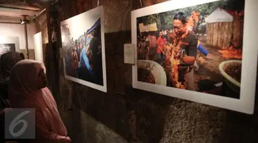 Pengunjung mengamati foto saat pameran foto Anugerah Pewarta Foto Indonesia (APFI) ke-VI di Gedung Bandung, Sabtu (9/4). APFI 2016 memamerkan 25 foto tunggal dan tiga foto seri terbaik sepanjang tahun 2015. (Liputan6.com/Faizal Fanani)