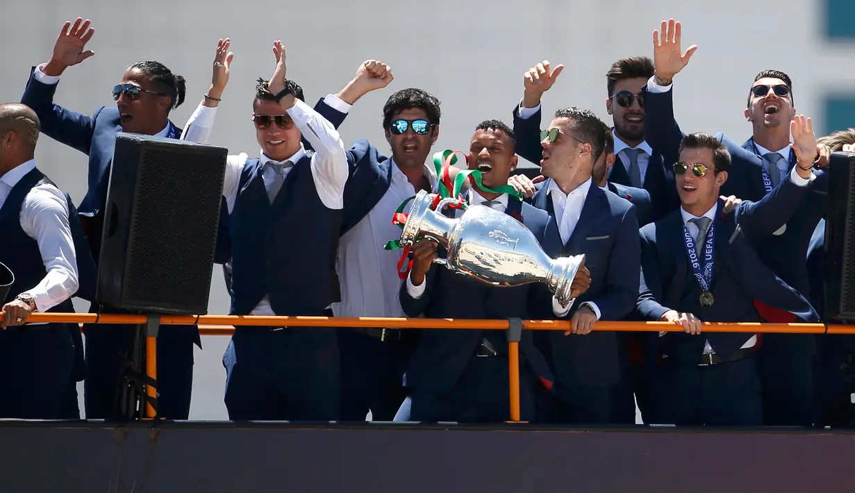 Cristiano Ronaldo dan tim kesebelasan menyapa pendukung mereka di atas bus terbuka saat kembali ke Lisbon, Portugal, Senin (11/7). Portugal menjadi juara Piala Eropa 2016 usai mengalahkan Prancis di final. (REUTERS / Rafael Marchante)