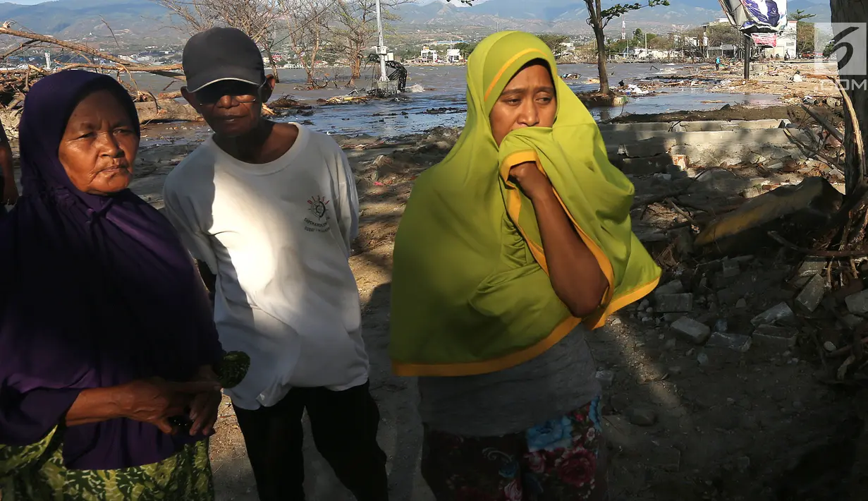 Lita (kanan) dan keluarga berusaha mencari anaknya, Nanang Kosim (20) yang belum ditemukan pascagempa dan tsunami Palu di Pantai Talise, Sulawesi Tengah, Senin (8/10). Nanang diduga masih tertimbun di dalam tanah saat tsunami. (Liputan6.com/Fery Pradolo)