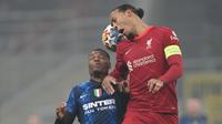 Bek Liverpool Virgil van Dijk menyundul bola melewati bek Inter Milan Denzel Dumfries pada leg pertama babak 16 besar Liga Champions di Stadion Giuseppe Meazza, Milan, Kamis dini hari WIB (17/2/2022). Melawat ke markas Inter Milan,  Liverpool menang 2-0. (AP Photo/Antonio Calanni)