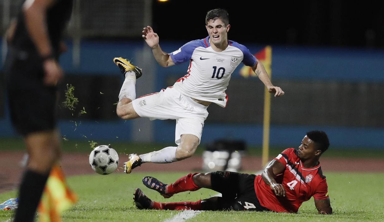 Gelandang Amerika Serikat, Christian Pulisic, terjatuh saat dilanggar pemain Trinidad Tobago pada laga kualifikasi Piala Dunia di Stadion Ato Boldon, Selasa (10/10/2017). Trinidad dan Tobago menang 2-1 atas  Amerika Serikat. (AP/Rebecca Blackwell)