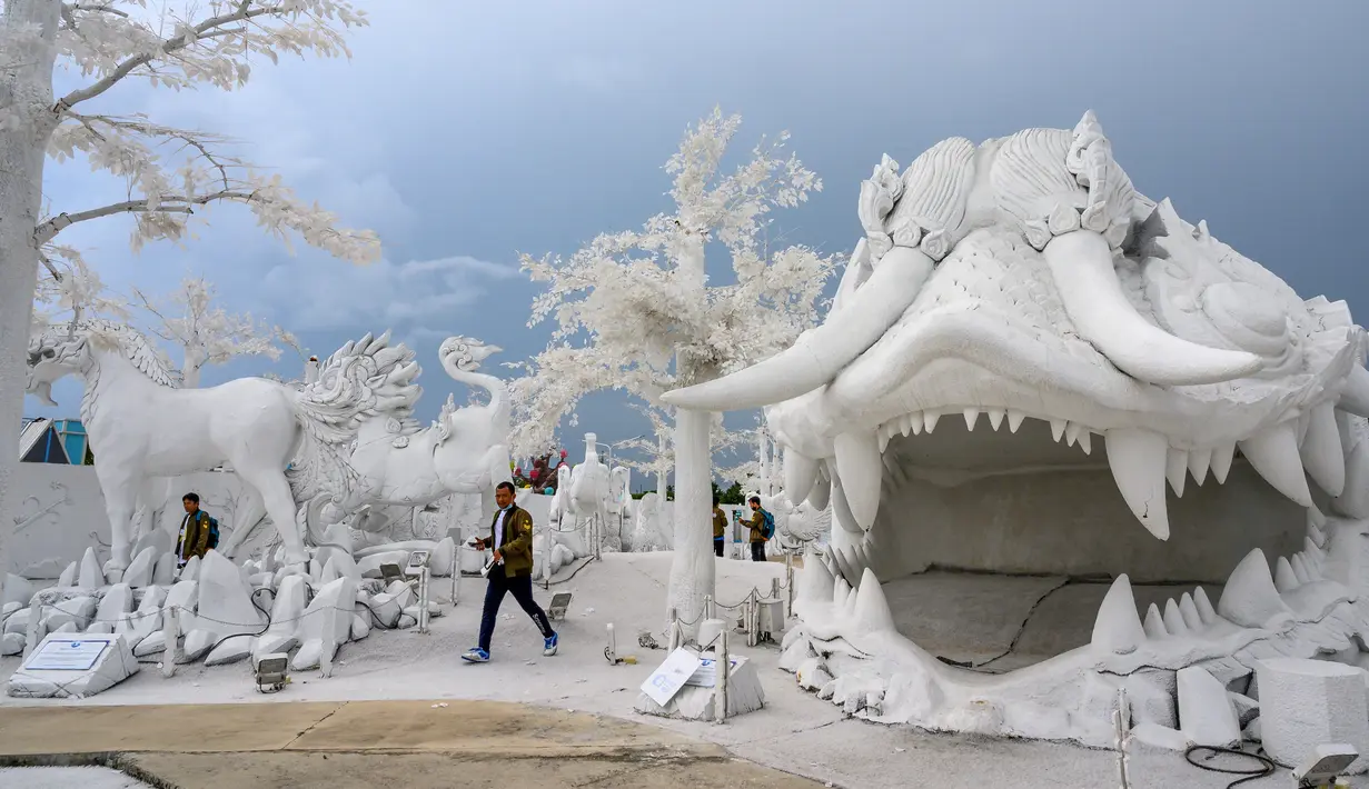 Foto pada yang diabadikan 2 September 2020 memperlihatkan pengunjung berfoto di depan patung dari pasir putih yang menyerupai es di taman "Frost Magical Ice of Siam", di luar Pattaya, Thailand. (Photo by Mladen ANTONOV / AFP)