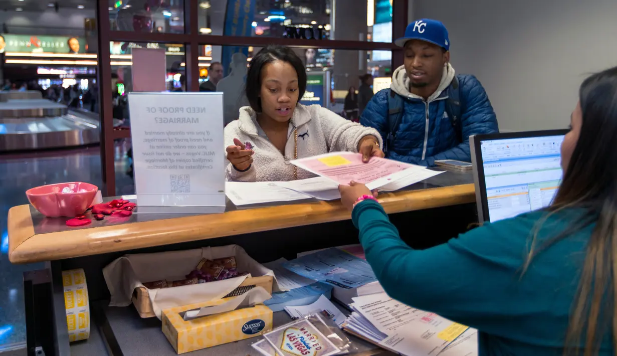 Sepasang calon pengantin Teaira Thompson dan James Anderson menyelesaikan dokumen mereka di Clark County Clerk's di Bandara Internasional McCarran di Las Vegas (12/2). Las Vegas ini menawarkan variasi pernikahan paling banyak. (AFP/L.E. Baskow)