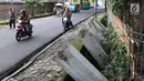 Pengendara sepeda motor melintasi pagar yang ambruk di Taman Hutan Tebet, Jakarta, Kamis (28/3). Pagar yang ambruk tidak diperbaiki melainkan diganti menggunakan bambu. (Liputan6.com/Immanuel Antonius)