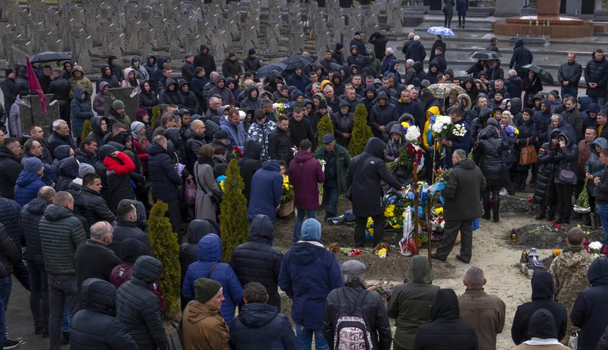 Keluarga dan teman menghadiri pemakaman Sersan Kostiv Andrew (37) yang tewas dalam perang dengan Rusia di pemakaman Lychakiv, Lviv, Ukraina, Selasa (5/4/2022). (AP Photo/Nariman El-Mofty)