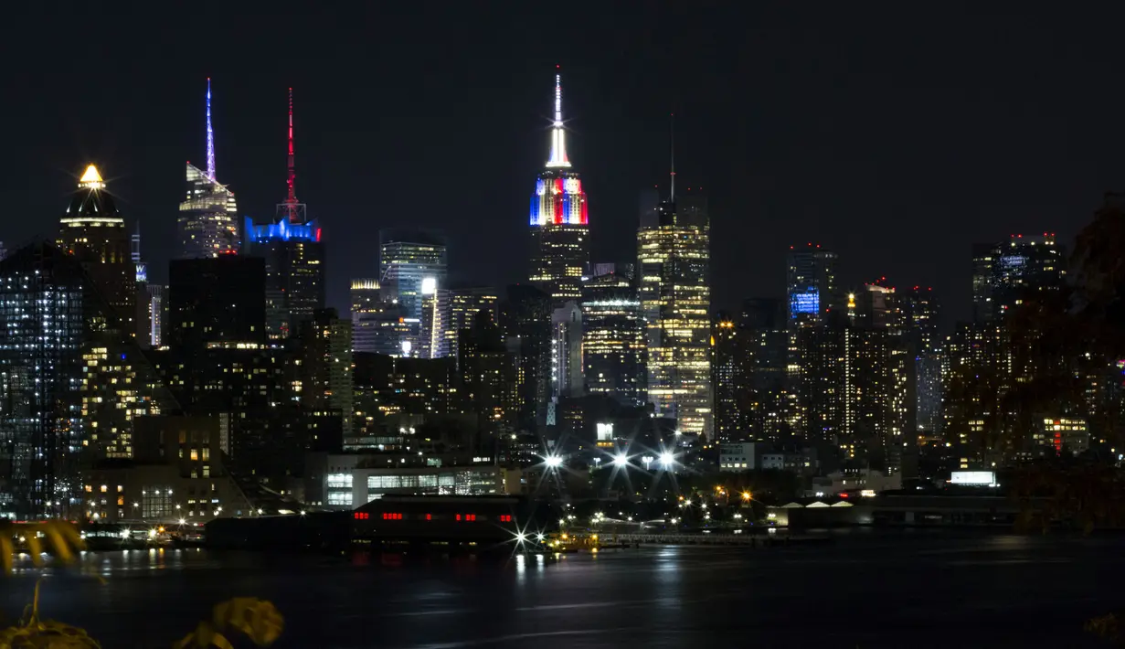 Gedung pencakar langit Empire State di New York memancarkan lampu warna bendera juara Piala Dunia 2018, Prancis, Minggu (15/7). Sebelumnya, pucak gedung terkenal di Amerika Serikat itu selalu menyalakan warna putih. (AFP PHOTO / KENA BETANCUR)