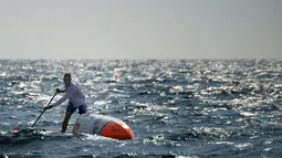 Nicolas bersemangat mendayung papan selancar saat berlatih di perairan lepas Martigues, Perancis, Selasa (15/3). Dengan menggunakan papan selancar dayung yang sudah dimodifikasi Jarossay akan menyeberangi Samudera Atlantik. (AFP/BORIS HORVAT)