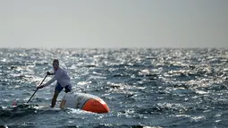 Nicolas bersemangat mendayung papan selancar saat berlatih di perairan lepas Martigues, Perancis, Selasa (15/3). Dengan menggunakan papan selancar dayung yang sudah dimodifikasi Jarossay akan menyeberangi Samudera Atlantik. (AFP/BORIS HORVAT)