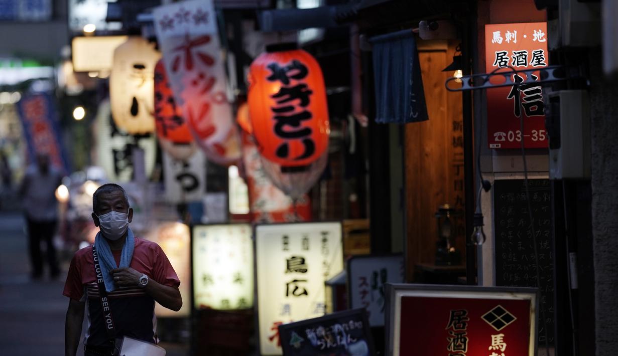 Seorang pria yang memakai masker untuk membantu mencegah penyebaran virus corona berjalan di sebuah jalan bar di Tokyo, Kamis (10/9/2020). Ibukota Jepang mengonfirmasi lebih dari 270 kasus virus korona pada hari Kamis. (AP Photo / Eugene Hoshiko)
