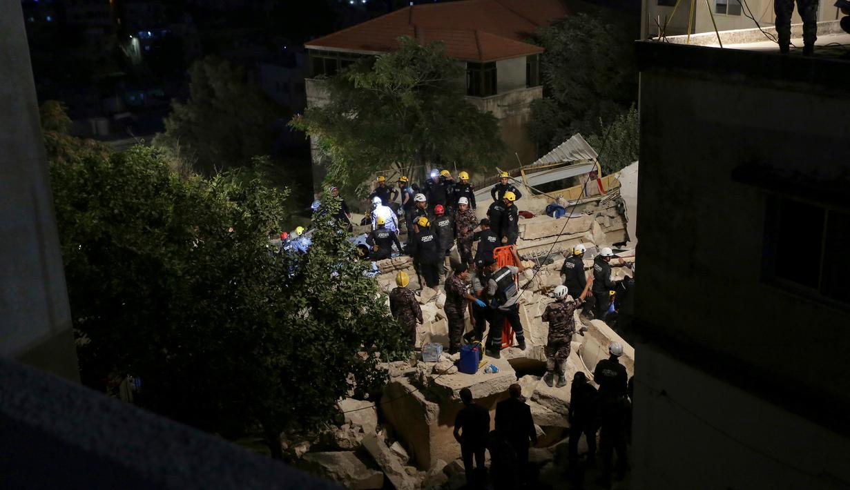 Tim penyelamat Pertahanan Sipil Yordania melakukan operasi pencarian terhadap penghuni sebuah bangunan perumahan berlantai empat yang runtuh di Amman, Yordania, Selasa (13/9/2022). Perdana Menteri Yordania Bisher Al Khasawneh sudah tiba di lokasi kejadian dan memerintahkan penyelidikan guna memastikan penyebabnya. (AP Photo/Raad Adayleh)