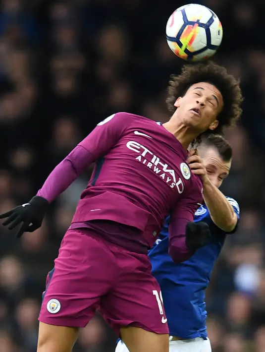 Gelandang Manchester City Leroy Sane berebut bola dengan gelandang Everton Morgan Schneiderlin saat pertandingan Liga Inggris di Goodison Park di Liverpool (31/3). (AFP Photo/Paul Ellis)