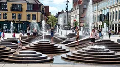 Anak-anak mendinginkan diri dengan bermain di air mancur saat gelombang panas menerjang Eropa di Toldbod Plads, Aalborg, Denmark, Rabu (24/7/2019). Eropa Barat dilanda gelombang panas yang hebat minggu ini. (Henning Bagger/Ritzau Scanpix via AP)