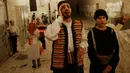 Kelompok pemuda Palestina berpakaian tradisional berteriak membangunkan kaum muslim untuk sahur di Kota Tua Yerusalem, Selasa (5/6). Dalam tradisi Musaharati ini biasanya mereka memakai alat musik sambil menyanyikan lagu-lagu religius. (AP/Mahmoud Illean)