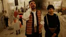 Kelompok pemuda Palestina berpakaian tradisional berteriak membangunkan kaum muslim untuk sahur di Kota Tua Yerusalem, Selasa (5/6). Dalam tradisi Musaharati ini biasanya mereka memakai alat musik sambil menyanyikan lagu-lagu religius. (AP/Mahmoud Illean)