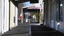 Orang-orang berjalan menyusuri jalur kafe yang biasanya ramai saat kota itu mengalami penguncian keenam saat memerangi wabah varian Delta dari coronavirus.di Melbourne (25/8/2021). (AFP/William West)