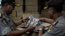 Polisi memeriksa sejumlah VCD dan DVD bajakan di Plaza Glodok, Jakarta, Rabu (24/6). Razia dilakukan karena pabrik sekaligus tempat penjualan DVD terbesar di DKI Jakarta itu masih beroperasi selama Ramadan. (Liputan6.com/Faizal Fanani)