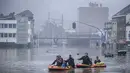 Warga menggunakan rakit karet di tengah banjir setelah Sungai Meuse jebol saat banjir besar di Liege, Belgia, Kamis (15/7/2021). Hujan lebat dan banjir telah menewaskan sedikitnya 59 orang di Jerman dan sembilan di Belgia. (AP Photo/Valentin Bianchi)