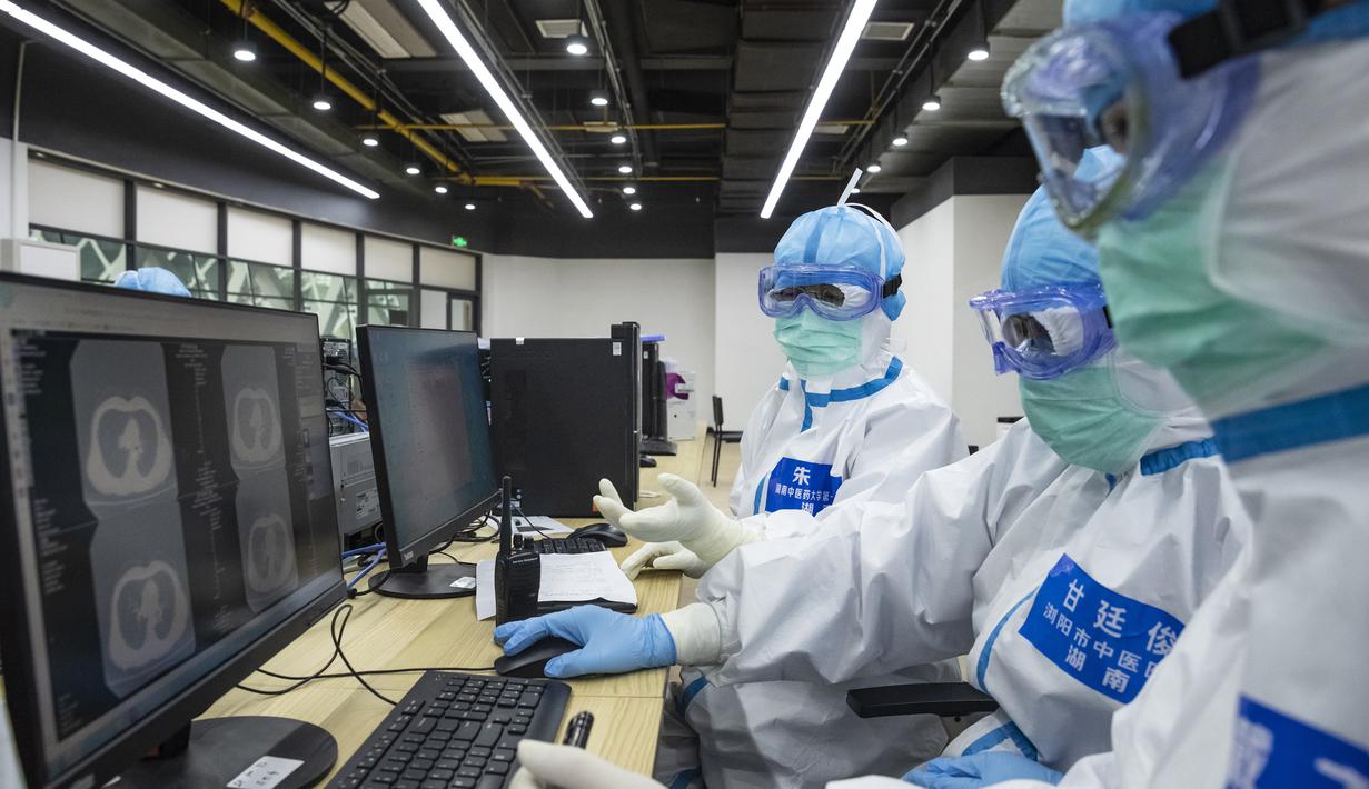 Para dokter memeriksa citra tomografi terkomputasi (computed tomography/CT) milik pasien di rumah sakit sementara di Distrik Jiangxia, Wuhan, Provinsi Hubei, China tengah, (25/2/2020). Rumah sakit darurat yang terletak di Distrik Jiangxia, Wuhan, itu diubah dari pusat olahraga. (Xinhua/Shen Bohan)