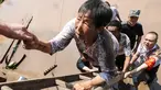 Pejabat desa mengevakuasi penduduk dari daerah banjir setelah hujan lebat di Dazhou di provinsi Sichuan barat daya China (12/7/2021). Banjir akibat hujan lebat melanda sejumlah wilayah di China. (AFP/STR)