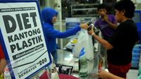 Konsumen membawa barang yang telah dibeli menggunakan kantong plastik di salah satu mini market di Pasar Baru, Jakarta, Senin (22/2). Peraturan ini serentak di 17 kota Indonesia dengan pembayaran Rp200 per kantong plastik. (Liputan6.com/Gempur M Surya)