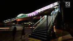 Lampu yang bisa berganti-ganti warna menghiasi jembatan penyeberangan orang (JPO) di kawasan Jakarta Timur, Kamis (27/12). Jembatan ini dihiasi warna warni lampu dengan fasilitas lift untuk para disabilitas menyeberang jalan. (Merdeka.com/Imam Buhori)