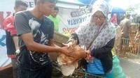 Striker Persip, Muhamad Ulum (kiri), saat melayani pembeli ayam potong jualannya di Pasar Hilir, Kota Pekalongan. (Bola.com/Robby Firly)