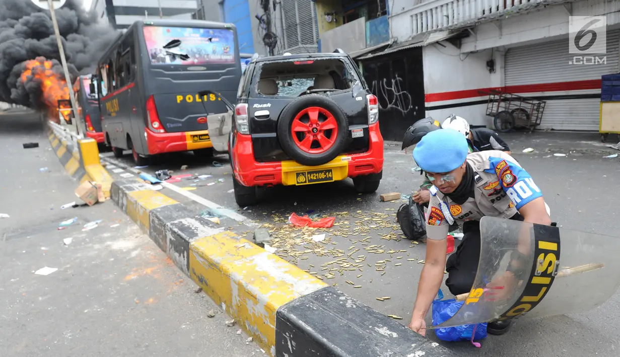 Warga, Polisi dan TNI mengambil peluru setelah kendaraan Polisi terbakar di Jalan Brigjen Katamso, Slipi, Jakarta, Rabu (22/5/2019). Belum diketahui penyebab terbakarnya dua bus yang terparkir bersama bus polisi lainnya dilokasi tersebut. (merdeka.com/Arie Basuki)
