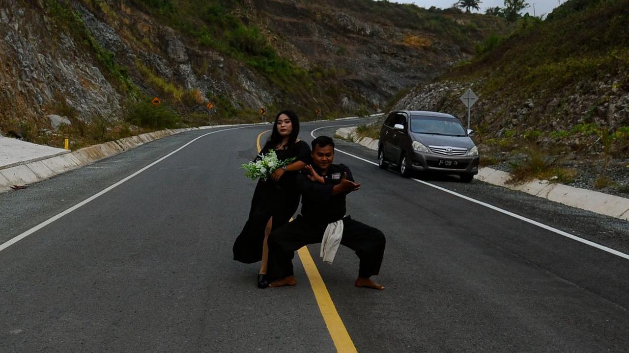 Pasangan itu menunjukkan posenya dengan berdiri di tengah jalan Jalur Pantai Selatan yang menghubungkan Tulungagung-Trenggalek di Watulimo, Trenggalek Jawa Timur.