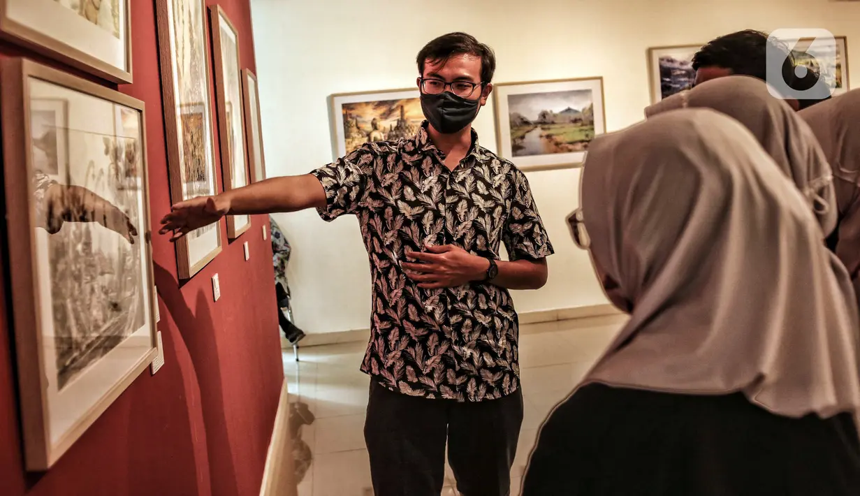 Seorang pria menjelaskan kepada para pengunjung karya yang ditampilkan dalam pameran International Watercolor 2022 "Wonderful Indonesia" di Gedung B Galeri Nasional Indonesia, Jakarta Pusat, Kamis (24/11/2022). Pameran ini bertujuan untuk memperkenalkan pesona Indonesia lewat karakter berbeda dan upaya untuk memasyarakatkan seni lukis cat air kepada khalayak. (merdeka.com/Iqbal S. Nugroho)