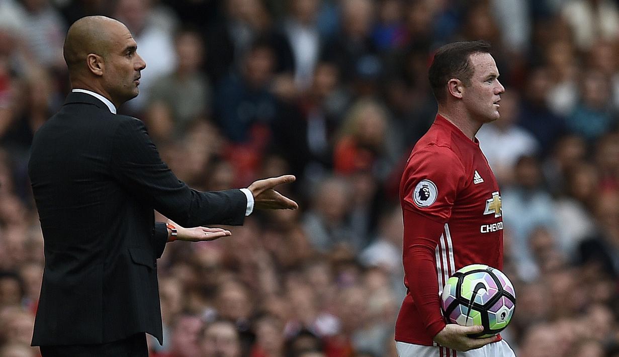 Wayne Rooney (kanan) dan pelatih Manchester City, Pep Guardiola terlibat insiden berebut bola pada laga Premier League di Old Trafford, Manchester,  (10/9/2016). (AFP/Oli Scarff)