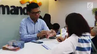 Petugas melayani transaksi setoran nasabah di cabang Bank Mandiri Pertamina UPMS III, Jakarta, Rabu (28/6). Bank Mandiri beroperasi secara terbatas untuk melayani nasabah pada musim liburan Idul Fitri 26-30 Juni 2017. (Liputan6.com/Angga Yuniar)