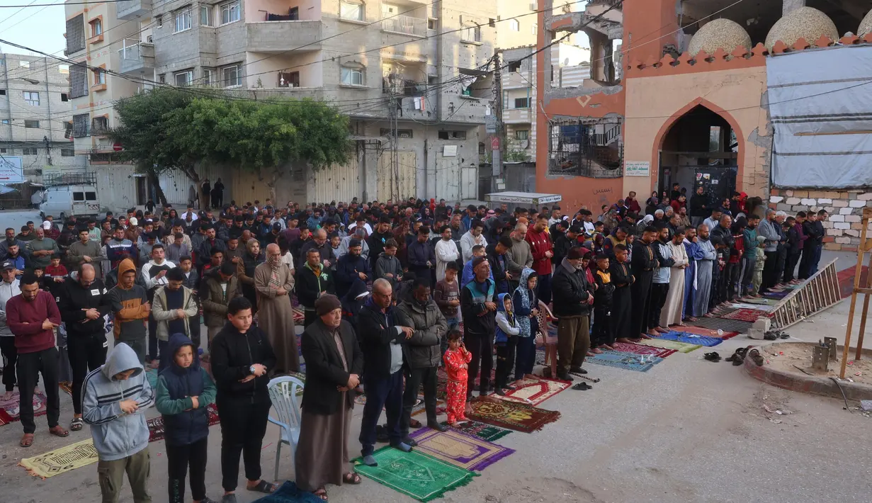 Warga Palestina melaksanakan salat Idul Fitri, yang menandai berakhirnya bulan suci Ramadan, di kamp Nuseirat untuk pengungsi Palestina di Jalur Gaza tengah pada 30 Maret 2025. (Eyad BABA/AFP)