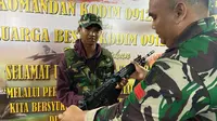 Seorang anggota Kodim 0912 Kutai Barat mengenalkan senapan serbu kepada seorang warga Kutai Barat di Festival Dahau.