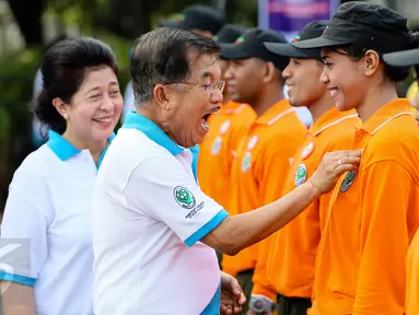 Wakil Presiden Jusuf Kalla didamping Menteri Kesehatan Nila Djuwita F. Moeloek saat menyematkan pin pada peserta jalan sehat saat Puncak Hari Kesehatan Nasional Ke-51 di Silang Monas, Jakarta, Minggu (6/12/2015). (Liputan6.com/Faizal Fanani)