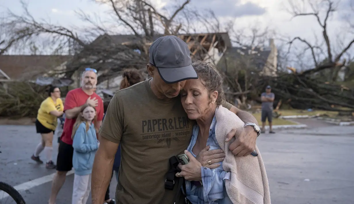 Michael Talamantez menghibur pacarnya Derry Schroer setelah rumah Talamantez di Stratford Drive di Round Rock, Texas dihancurkan badai tornado, ketika mereka berada di dalam rumah, Senin (21/3/2022). "Saya pikir saya akan mati ," dia berkata. (Jay Janner/Austin American-Statesman via AP)