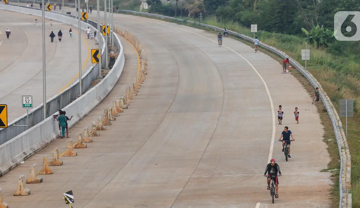 Warga bersepeda pada waktu sore di kawasan pembangunan Tol Serpong Kunciran, Ciputat, Tangerang Selatan, Kamis (25/6/2020). Sebagian warga terlihat tidak mengindahkan protokol kesehatan seperti menggunakan masker dan physical distancing. (Liputan6.com/Fery Pradolo)