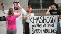 Seorang demonstran berpakaian seperti Putra Mahkota Arab Saudi Pangeran Mohammed bin Salman dengan tangan penuh darah menggelar protes di luar Kedutaan Saudi di Washington, AS, 8 Oktober 2018. (JIM WATSON/AFP)