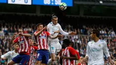 Pemain depan Real Madrid Gareth Bale berebut bola dengan pemain Atletico Madrid saat pertandingan La Liga Spanyol di stadion Santiago Bernabeu di Madrid (8/4). Real Madrid harus puas ditahan imbang 1-1 oleh Atletico Madrid. (AP Photo / Francisco Seco)