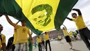 Suporter membentangkan gambar legenda sepak bola Brasil, Pele, jelang menyaksikan laga Kamerun vs Brasil di Stadion Nasional Brasil, (23/6/2014). (REUTERS/Ueslei Marcelino)