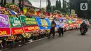 Pengguna jalan melintasi karangan bunga untuk terdakwa  kasus obstruction of justice perintangan penyidikan tewasnya Brigadir J, Hendra Kurniawan di depan Pengadilan Negeri Jakarta Selatan, Senin (27/2/2023). Berbagai ucapan serta dukungan datang dari sejumlah elemen masyarakat untuk Hendra Kurniawan akan menjalani sidang vonis kasus perintangan penyidikan kematian Nofriansyah Yosua Hutabarat alias Brigadir J. (Liputan6.com/Angga Yuniar)