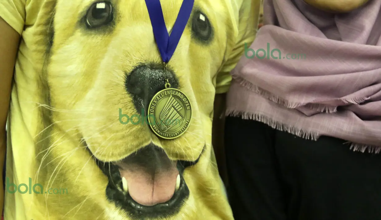 Praveen Jordan mengenakan kaos bergambar anjing dengan medali emas All England saat tiba di Bandara Soekarno-Hatta, Tangerang, Rabu (16/3/2016).  (Bola.com/Nicklas Hanoatubun)