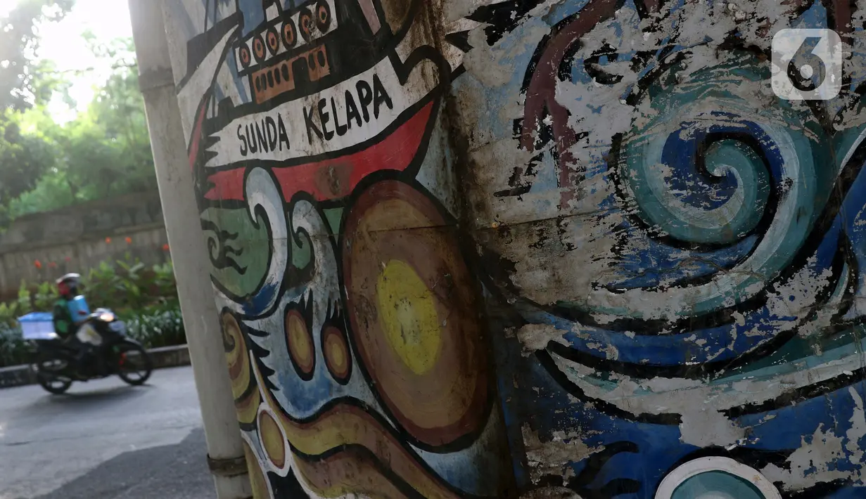 Pengendara motor melintasi sisi tiang penyangga Jalan Tol Pelabuhan Lingkar Dalam Jakarta di Jalan Ancol Timur, Jakarta, Selasa (16/6/2020). Seni mural yang dulu menghiasi tiang-tiang jalan tol di kawasan tersebut kini terlihat kusam dan berdebu. (Liputan6.com/Helmi Fithriansyah)