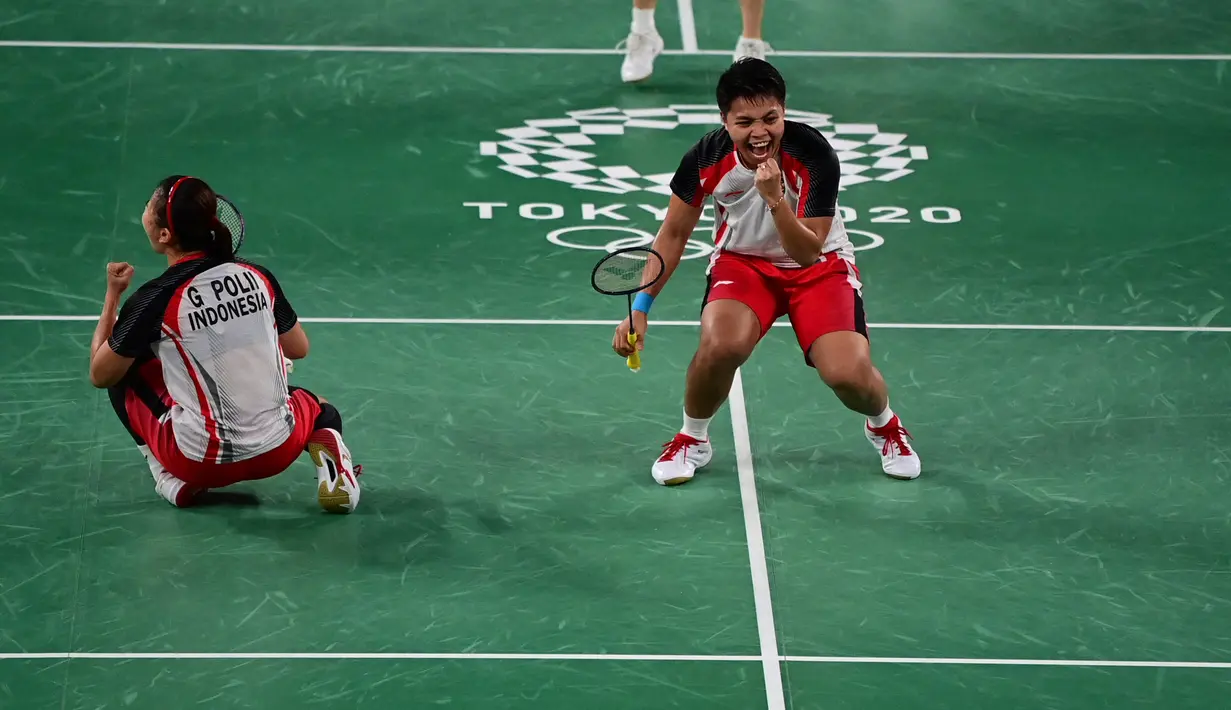 Reaksi ganda putri Indonesia Apriyani Rahayu dan Greysia Polii saat melawan Chen Qing Chen dan Jia Yi Fan dari China pada final badminton ganda putri Olimpiade Tokyo 2020 di Musashino Forest Sport, Senin (2/8/2021). (Pedro PARDO/AFP)