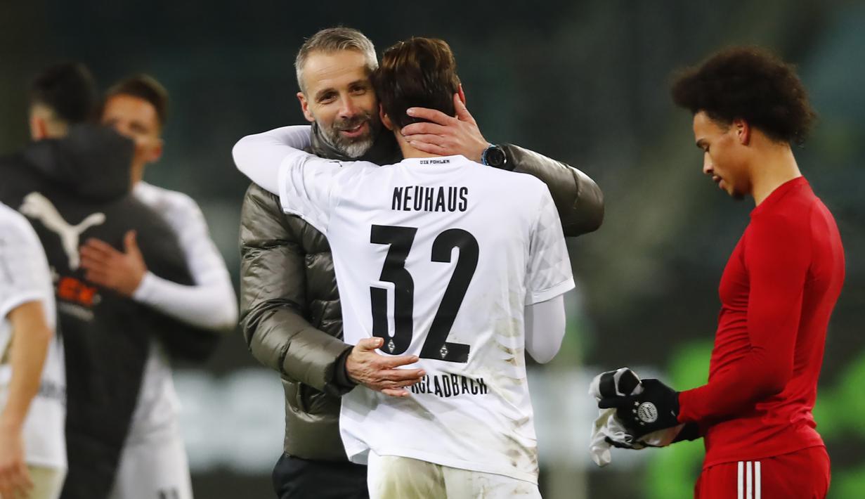 Manajer tim Borussia Moenchengladbach, Marco Rose bersama gelandang Florian Neuhaus merayakan kemenangan 3-2 atas Bayern Munich usai berakhirnya laga lanjutan Liga Jerman 2020/21 pekan ke-15 di Borussia Park, Jumat (8/1/2021). (AFP/Wolfgang Rattay/Pool)