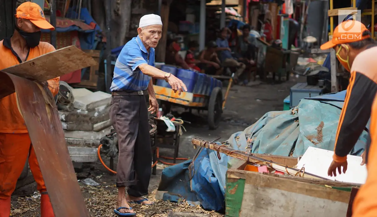 Petugas PPSU membongkar bangunan kios pedagang nasi kapau di Jalan Kramat Raya, Senen, Jakarta, Jumat (6/9/2019). Pembongkaran disebabkan adanya rencana revitalisasi trotoar di jalan tersebut. (Liputan6.com/Immanuel Antonius)