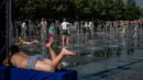 Anak-anak mendinginkan diri di air mancur Taman Muzeon saat suhu udara mendekati 31 derajat celcius di Moskow (31/8/2020). Akibat perubahan suhu tersebut, Moskow menjadi salah satu wilayah terpanas di Rusia. (AFP/DIMITAR DILKOFF)