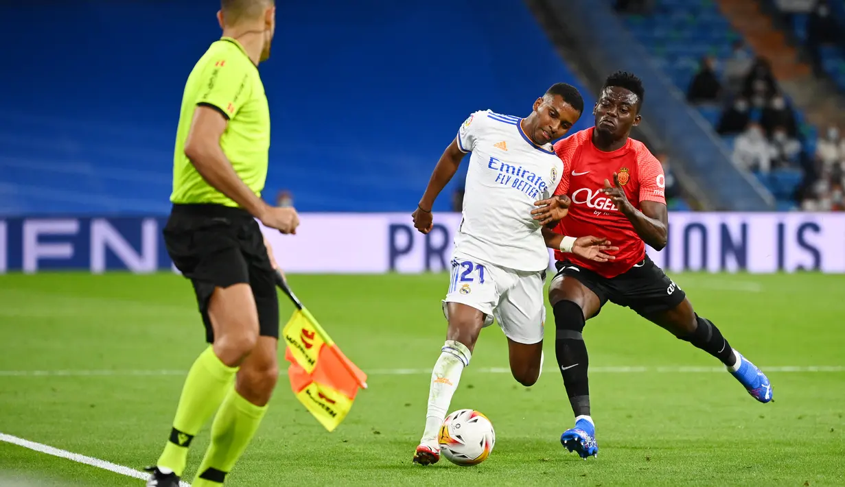 Pemain depan Real Madrid Rodrygo ditantang oleh gelandang Mallorca, Iddrisu Baba (kanan) pada jornada keenam La Liga Spanyol di Santiago Bernabeu, Kamis (23/9/2021) dini hari WIB. Real Madrid berpesta gol usai melibas Real Mallorca 6-1. (GABRIEL BOUYS / AFP)