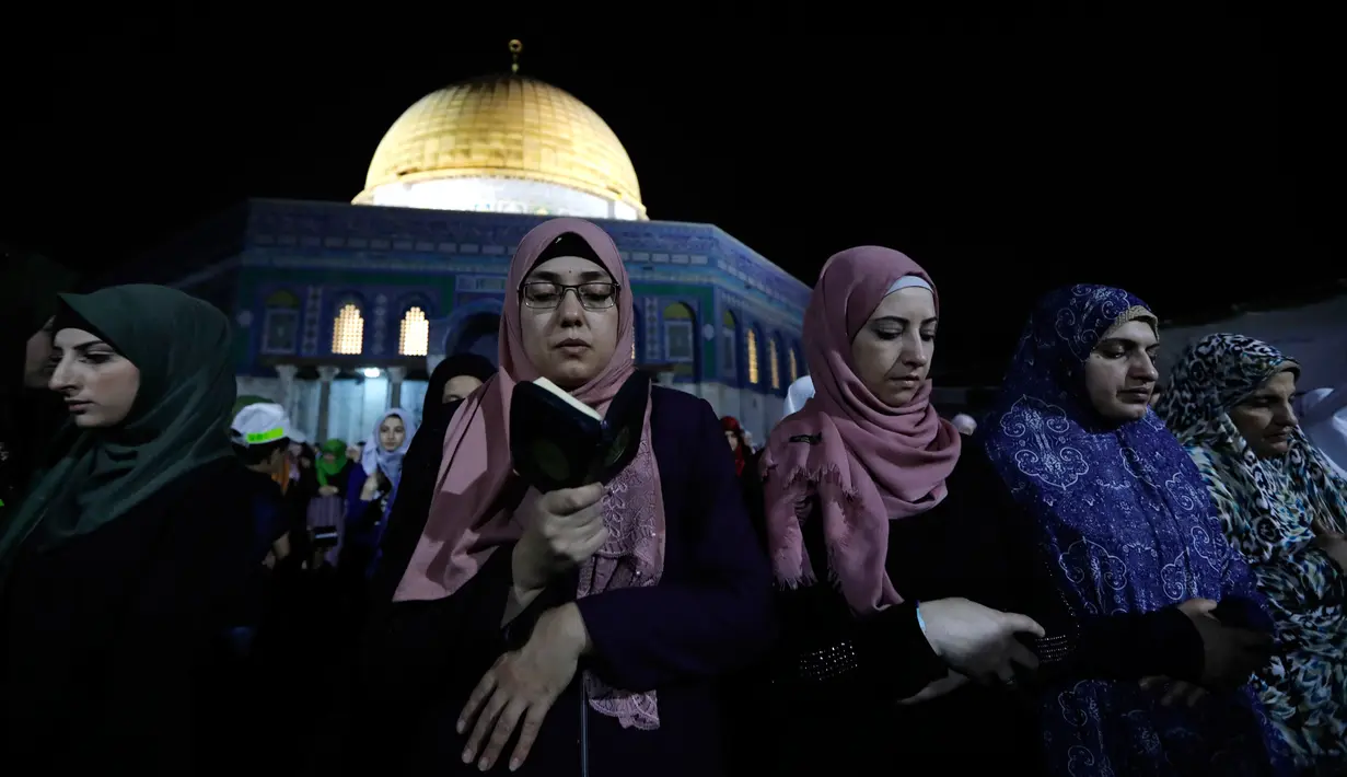 Muslim Palestina memanjatkan doa sambil menunggu Lailatul Qadar di luar Dome of the Rock, kompleks masjid Al-Aqsa di Kota Tua Yerusalem, Senin (11/6). Malam ganjil menjadi prioritas muslim beriktikaf untuk mendapat Lailatul Qadar. (AFP/AHMAD GHARABLI)