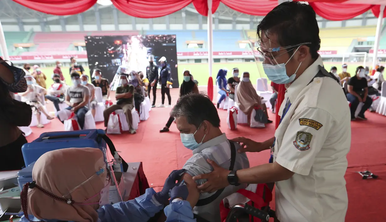 Seorang penyandang disabilitas menerima suntikan vaksin Sinovac saat vaksinasi massal virus corona COVID-19 untuk umum di Stadion Patriot Candrabhaga, Bekasi, Jawa Barat, Senin (14/6/2021). Peminat vaksinasi COVID-19 di Stadion Patriot Candrabagha sangat tinggi. (AP Photo/Achmad Ibrahim)